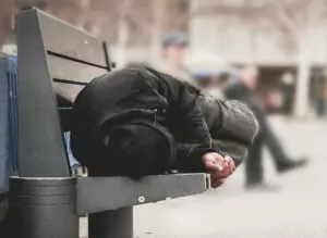 A homeless man is sleeping on bench